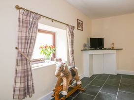 A snug with a rocking horse and television at Camellia Cottage in Bodmin