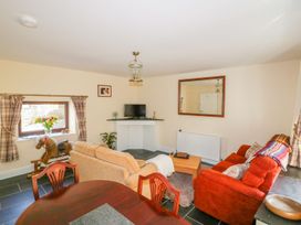 A living room with a sofa and dining table at Camellia Cottage in Bodmin
