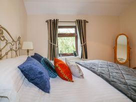 A bedroom with a bed and window at Camellia Cottage in Bodmin