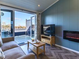 A living room with a sofa and television at Coniston (Pet) Penrith