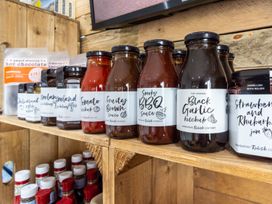 A shelf displaying various sauces and jams at Coniston (Pet) Penrith