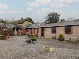 An outdoor area with a cottage, gravel, table and chairs at Apple Cottage in Whitchurch Canonicorum