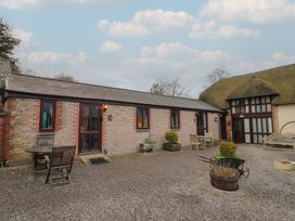 An outdoor area with seating and a brick building at Apple Cottage in Whitchurch Canonicorum