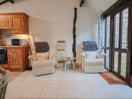 A snug with kitchen features and seating at Apple Cottage in Whitchurch Canonicorum