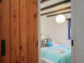 A bedroom with a bed and light fixture at Apple Cottage Whitchurch Canonicorum