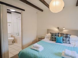 A bedroom with a bed and adjoining bathroom at Apple Cottage Whitchurch Canonicorum