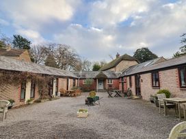 An outdoor area with buildings and seating at Apple Cottage in Whitchurch Canonicorum