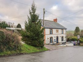 A pub building with a signpost and tree at Apple Cottage in Whitchurch Canonicorum