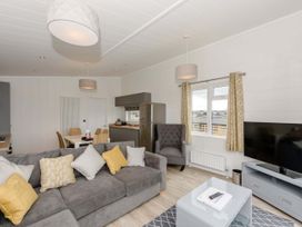 A living room with a sofa, table, and television at Blencathra Family (Pet) in Penrith