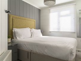 A bedroom with a bed and nightstand at Blencathra Family (Pet) in Penrith