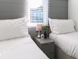 A bedroom with two beds and a nightstand at Blencathra Family (Pet) Penrith