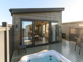 An outdoor area with a hot tub and sliding doors at Grasmere in Penrith