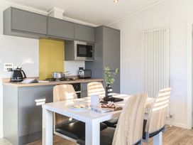 A kitchen with a dining table and modern appliances at Grasmere in Penrith