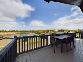 A balcony with a table and chairs overlooking a lake at Keswick in Penrith
