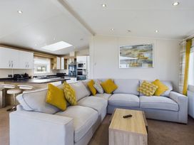 A living room with a sofa and kitchen area at Keswick in Penrith