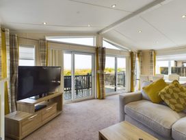 A living room with a television and sliding doors at Keswick in Penrith