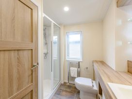 A bathroom with a shower, toilet, and sink at Keswick in Penrith