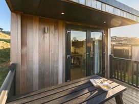 A balcony with a table and snacks at Pods by the Lake in Penrith