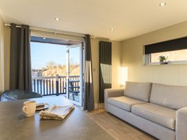 A living room with a sofa and table at Pods by the Lake in Penrith