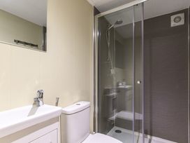 A bathroom with a shower, sink, and toilet at Pods by the Lake Penrith