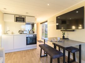 A kitchen with appliances and a dining area at Pods by the Lake (Pet) Penrith
