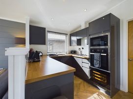 A kitchen with cabinets and appliances at Spa Sauna Lodge in Penrith