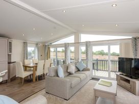 A living room with a sofa and dining area at Helvellyn in Penrith