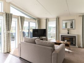 A living room with a sofa and television at Helvellyn (Pet) in Penrith