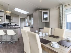 A kitchen with modern cabinets and dining area at Helvellyn (Pet) Penrith