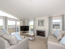 A living room with a sofa and television at Helvellyn (Pet) in Penrith