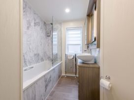A bathroom with a bathtub and a washbasin at Helvellyn (Pet) Penrith