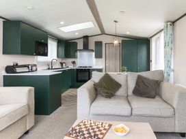 A living room with a kitchen area and chess game at Blencathra Spa (Pet) in Penrith