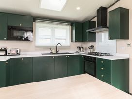 A kitchen with cabinets, stove, sink and appliances at Blencathra Spa (Pet) Penrith