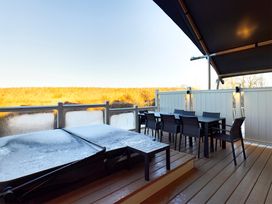 An outdoor area with a hot tub and dining set at Kruger in Penrith