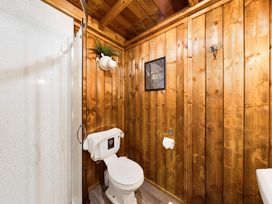 A bathroom with a shower, toilet, and framed picture at Kruger in Penrith
