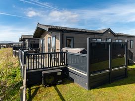 A row of buildings with decking and glass panels at Scaféll in Penrith