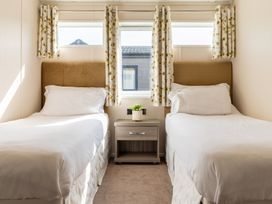 A bedroom with two beds and a bedside table at Scaféll in Penrith