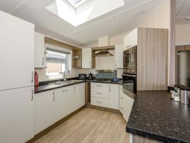 A kitchen with cabinets, sink, stove, and appliances at Scaféll in Penrith