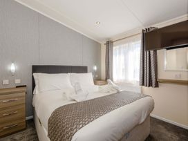 A bedroom with a bed and television at Scaféll in Penrith