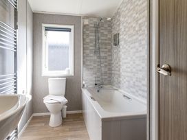 A bathroom with a bathtub and toilet at Scaféll (Pet) Penrith