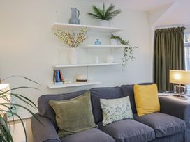 A living room with a sofa and shelves holding decorative items at Renes Shop in Grange-Over-Sands