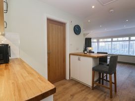 A kitchen with a bar counter and clock at Renes Shop in Grange-Over-Sands