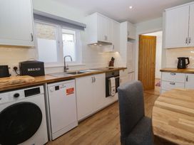 A kitchen with appliances and wooden table at Renes Shop in Grange-Over-Sands