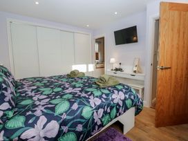 A bedroom with a bed and TV at Renes Shop in Grange-Over-Sands