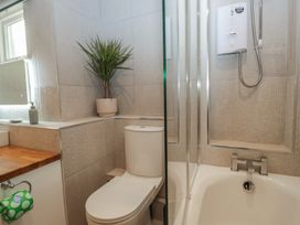 A bathroom with a toilet and bathtub at Renes Shop in Grange-Over-Sands
