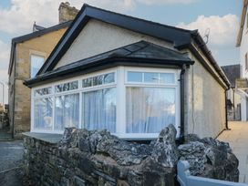 A house with large windows and a stone wall at Renes Shop in Grange-Over-Sands