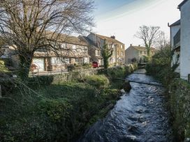 An outdoor view with houses and a stream at Renes Shop in Grange-Over-Sands