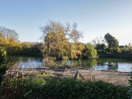 A pond with benches and trees at Renes Shop in Grange-Over-Sands