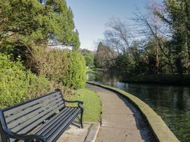A path alongside water and a bench at Renes Shop in Grange-Over-Sands