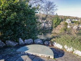 A plaque and foliage near a river at Renes Shop in Grange-Over-Sands